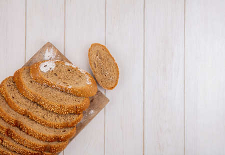 top view of sliced brown seeded cob on cutting board and on wooden background with copy spaceの写真素材