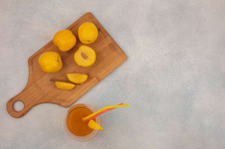 top view of fresh yellow peaches with fresh peach juice on a glass on a white background with copy spaceの写真素材
