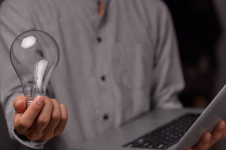 A man holding a light bulbの素材