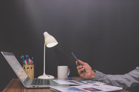 Business people use smartphones at their desksの素材