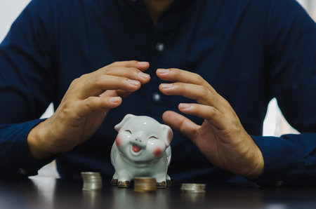 Finance concept business, collecting money for retirement or investing or sharing expenses. Drop a piggy bank.の素材