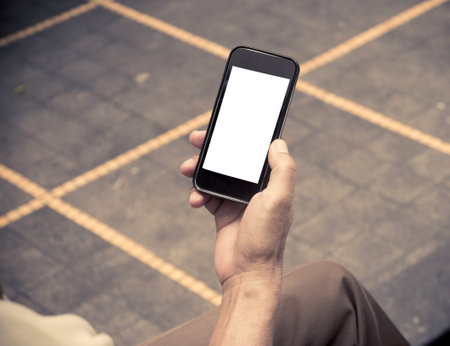 Close up hands multitasking man using smart phone.vintage effect style picturesの素材