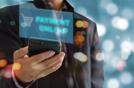 Man hand holding use mobile phones to payment online and shop online. Social distancing and working from home and digital marketing.の素材