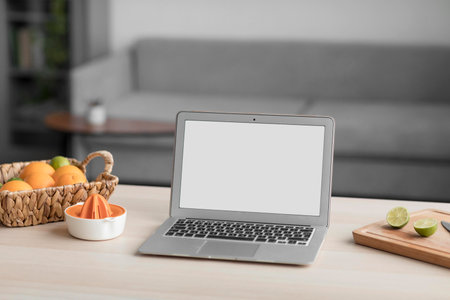 Citrus fruit and laptop with blank screen on a wooden tableの素材