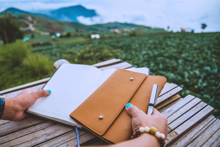 The woman hand holds the writings. Morning atmosphere The mountains are foggy. phetchabun phutubberg thailandの素材