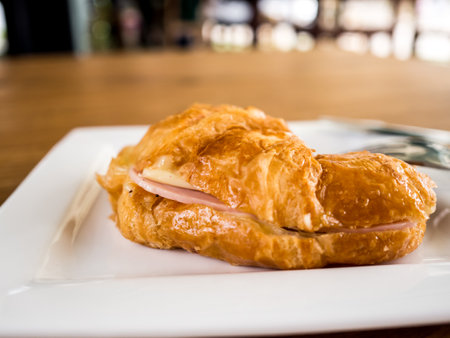 Ham cheese croissant served on wooden table in the cafe.の素材