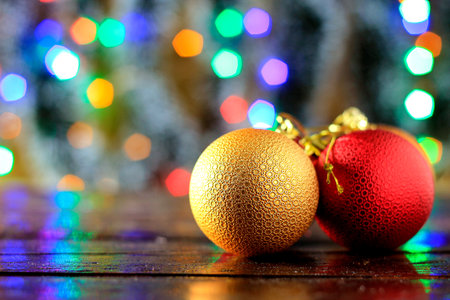 Red and golden sphere on wooden table, Christmas decoration with blurred lights backgroundの素材