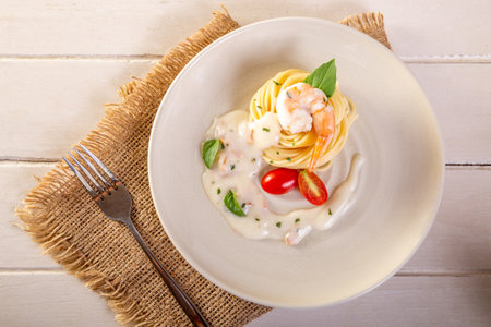 Spaghetti with shrimp and basil on a plateの素材