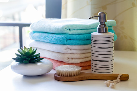 Stack of bath towels with toothbrushes on tableの素材