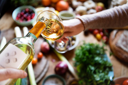 Couple having white wine while cooking in a kitchenの素材