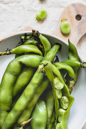 Fresh organic broad beans in a bowl aerial viewの素材
