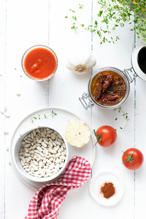 Raw white beans in a bowl by sun-dried tomatoesの素材