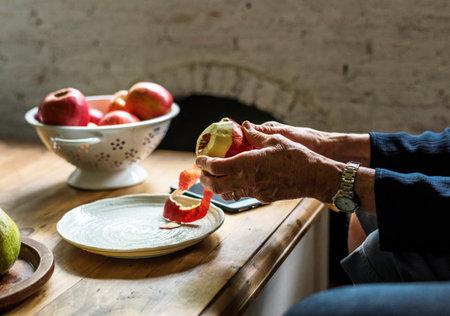 Closeup of hand with knife peeling appleの素材