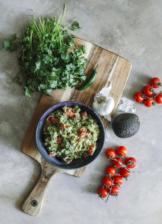 Homemade guacamole with cherry tomatoes food photography recipe ideaの素材
