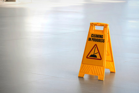 A bright yellow A-frame caution sign is placed on a reflective, clean floor.
