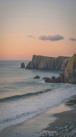A serene coastal scene at sunset, featuring a rocky coastline with waves gently lapping against the...