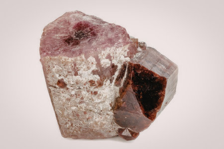 The image features a pink and red tourmaline crystal with a rough, unpolished surface. The crystal...