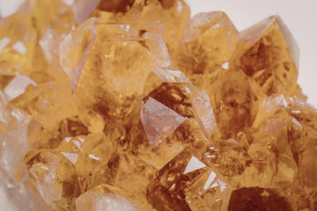 A close-up photograph of a cluster of citrine crystals with a white background.