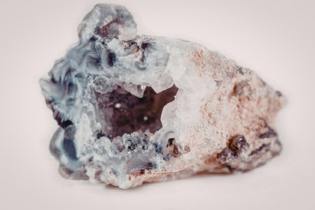 A large amethyst geode with a hollow center, showcasing its crystalline structure, set against a...