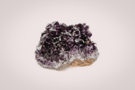 A cluster of purple amethyst crystals on a white backgroundの写真素材