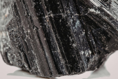 A close-up view of a black tourmaline mineral, showcasing its dark color and unique texture.