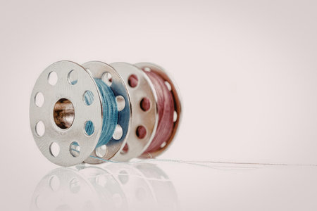 A stack of colorful metal spools with holes, arranged in a row on a white background.
