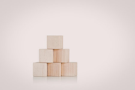 A stack of wooden blocks arranged in a pyramid shape on a white background