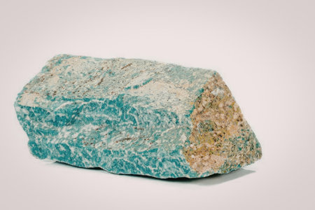 A raw piece of malachite with a rough texture and vibrant green color, showcasing its natural...