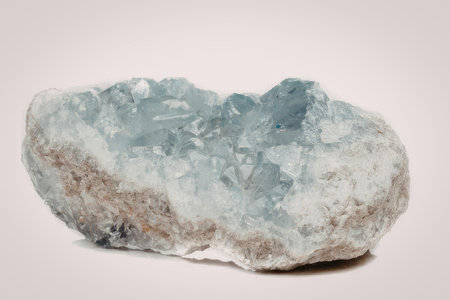 A large blue crystal geode with a rough exterior and a smooth, crystalline interior, set against a...