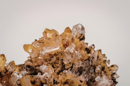 A close-up image of a cluster of citrine crystals with a warm orange-brown color, showcasing their unique shapes and facets against a plain white background.の写真素材