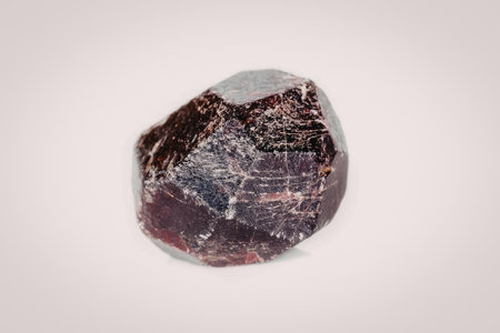 A close-up image of a large, rough-cut purple gemstone with pink undertones, showcasing its natural...