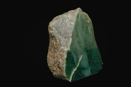 A large piece of green malachite mineral with a rough texture and a smooth, glossy surface, set...