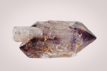 A large, pointed purple crystal with golden flecks and a clear protrusion on the left side, set...