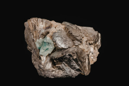 A rock with a green mineral deposit on a black background