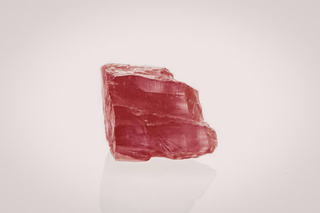 A vibrant pink quartz crystal on a white background
