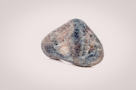 A close-up image of a single rock with a mottled surface, featuring shades of blue, brown, and gray.