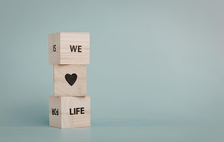 A stack of wooden blocks with a heart symbol and words 'we' and 'life' on them.