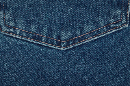A close-up view of a blue jeans pocket with visible stitching and fabric texture.