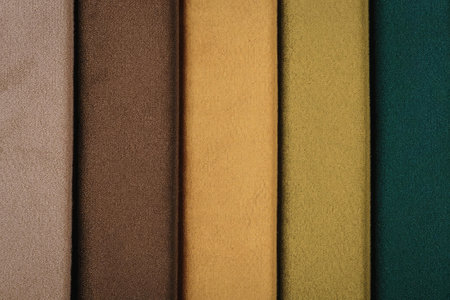 A collection of five fabric swatches in different colors, including beige, brown, orange, green, and...