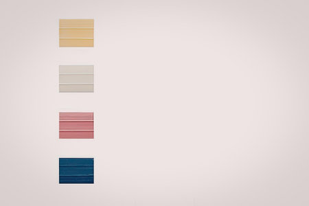 A collection of four color swatches in yellow, beige, pink, and blue.