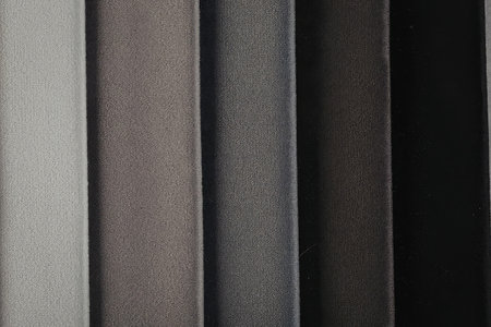This image showcases a variety of grey fabric shades, ranging from light to dark, with a focus on...
