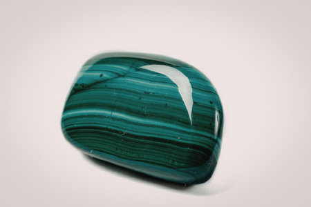 A close-up image of a polished malachite stone showcasing its vibrant green color and distinctive...
