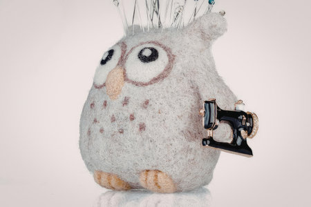 A small, fuzzy owl with big eyes and a yellow beak, wearing glasses and having feathers on its head.の写真素材