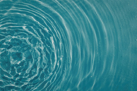 A close-up view of ripples on the surface of a body of water, likely a pool or a lake, showcasing...