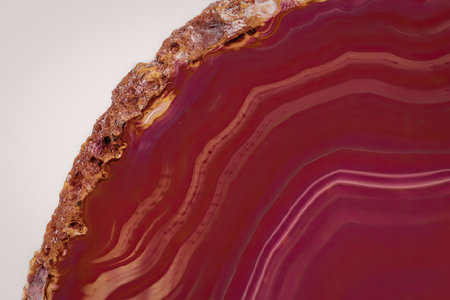 A close-up image of a vibrant pink agate geode slice, showcasing its intricate banded patterns and...