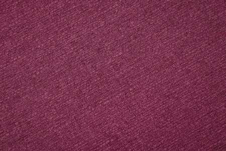 A close-up view of a vibrant magenta textured surface, possibly a fabric or paper background.