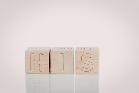 Three wooden blocks with letters H, I, S carved on them, arranged in a row on a reflective surface