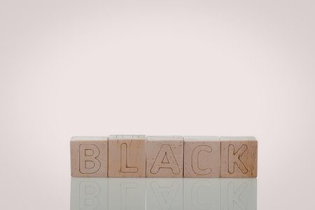 A row of wooden blocks with the word 'BLACK' carved into them, set against a white background.の写真素材