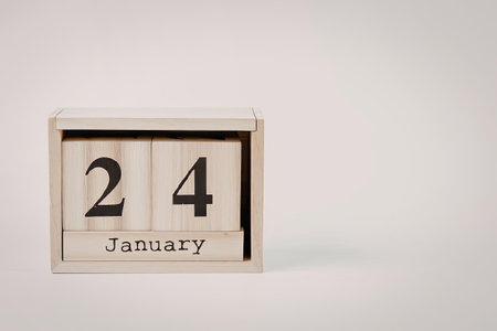 A wooden perpetual calendar block displaying the date January 24, with a simple and minimalist...