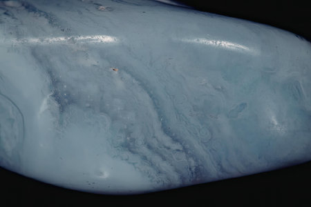 This image presents a close-up view of a blue stone, showcasing its smooth surface and intricate...